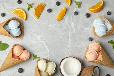 Flat lay composition with delicious ice creams in waffle cones on table, space for text