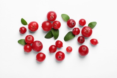 Photo of Fresh ripe cranberries and green leaves on white background, flat lay