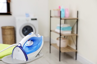 Modern clothes iron on board in laundry room