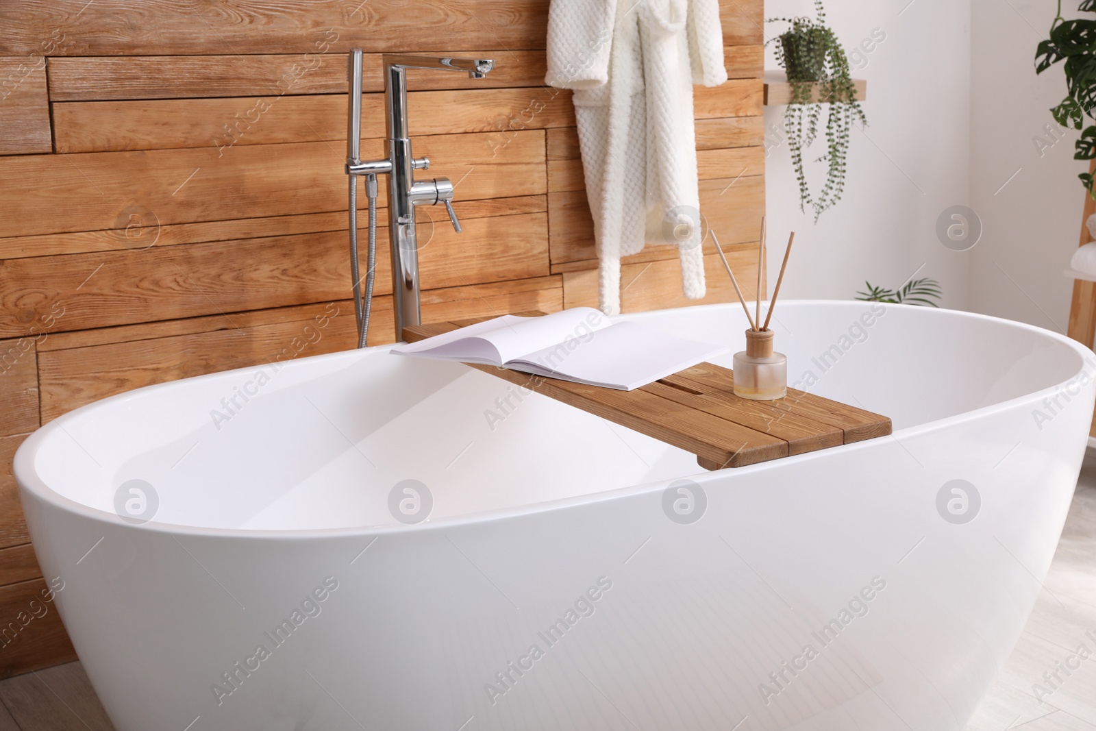 Photo of White tub and beautiful plants in bathroom, Interior design