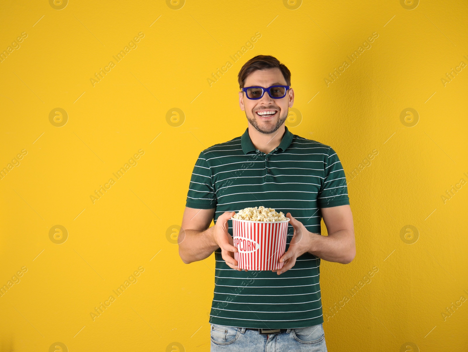 Photo of Man with 3D glasses and tasty popcorn on color background. Space for text
