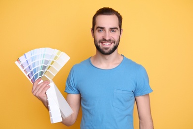 Photo of Young man with color palette on yellow background