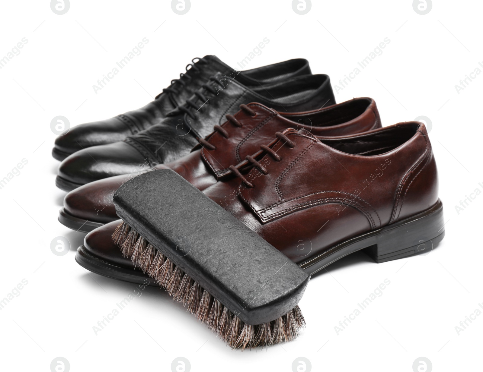 Photo of Stylish men's shoes and cleaning brush on white background