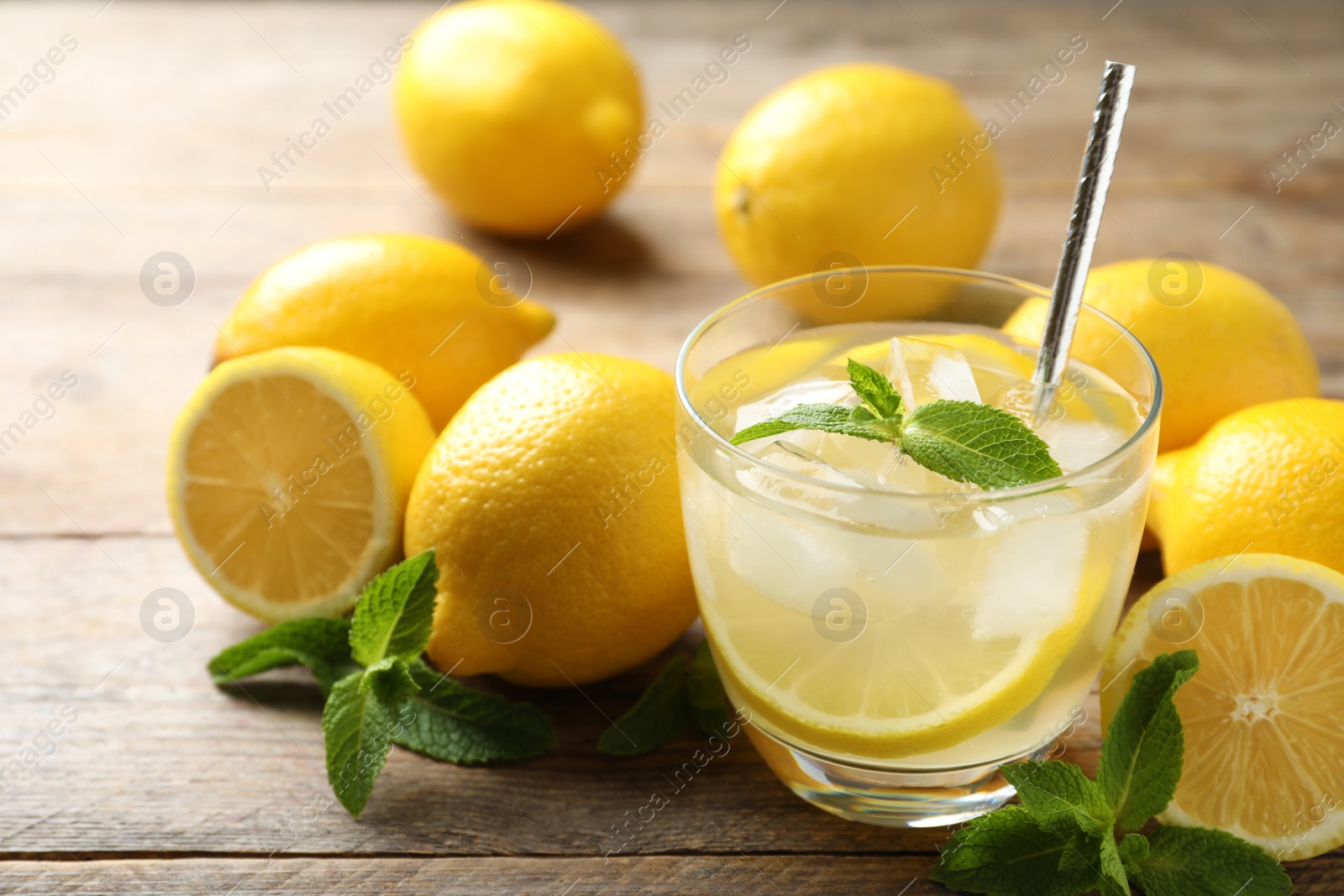 Photo of Natural lemonade with mint and fresh fruits on wooden table, closeup. Summer refreshing drink