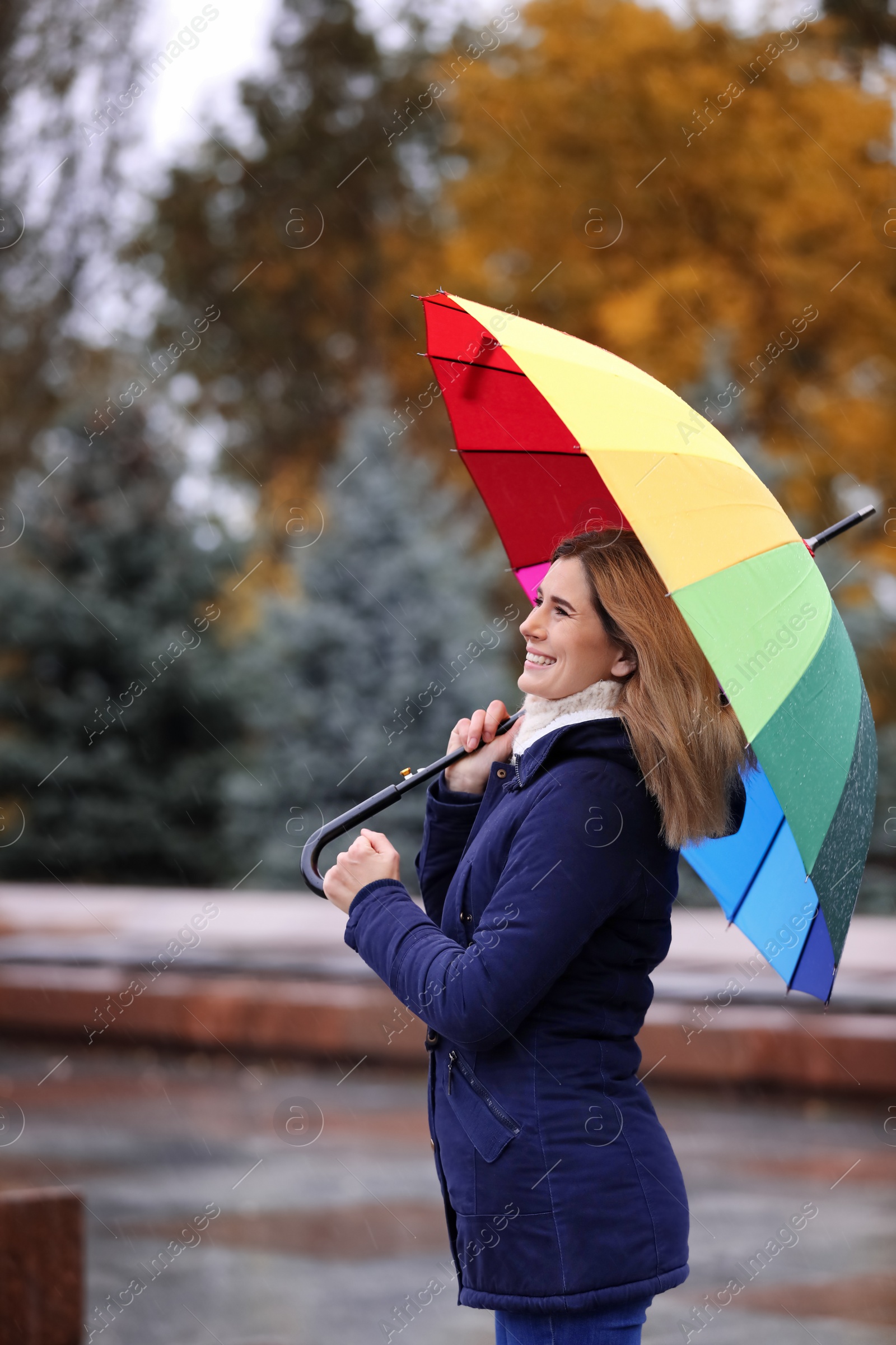 Photo of Woman with umbrella in autumn park on rainy day