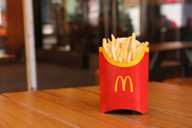 Photo of MYKOLAIV, UKRAINE - AUGUST 11, 2021: Big portion of McDonald's French fries on table in cafe. Space for text