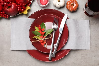 Beautiful place setting with autumn decor on grey table, flat lay