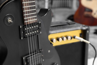 Photo of Electric guitar with amplifier at recording studio, closeup. Music band practice