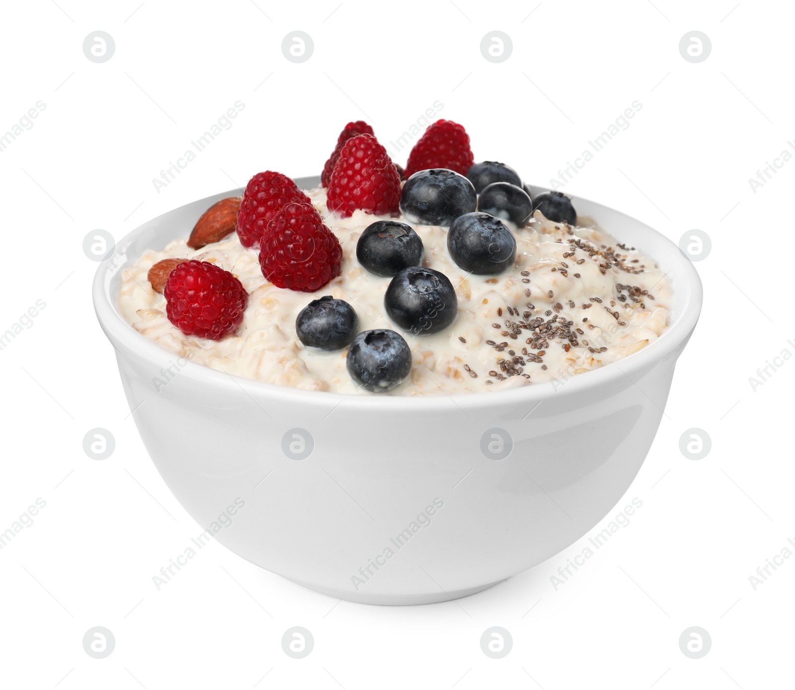 Photo of Tasty boiled oatmeal with berries, almonds and chia seeds in bowl isolated on white