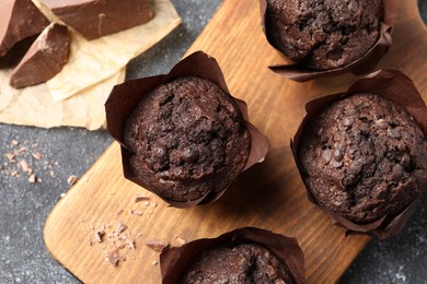 Tasty chocolate muffins on grey table, top view