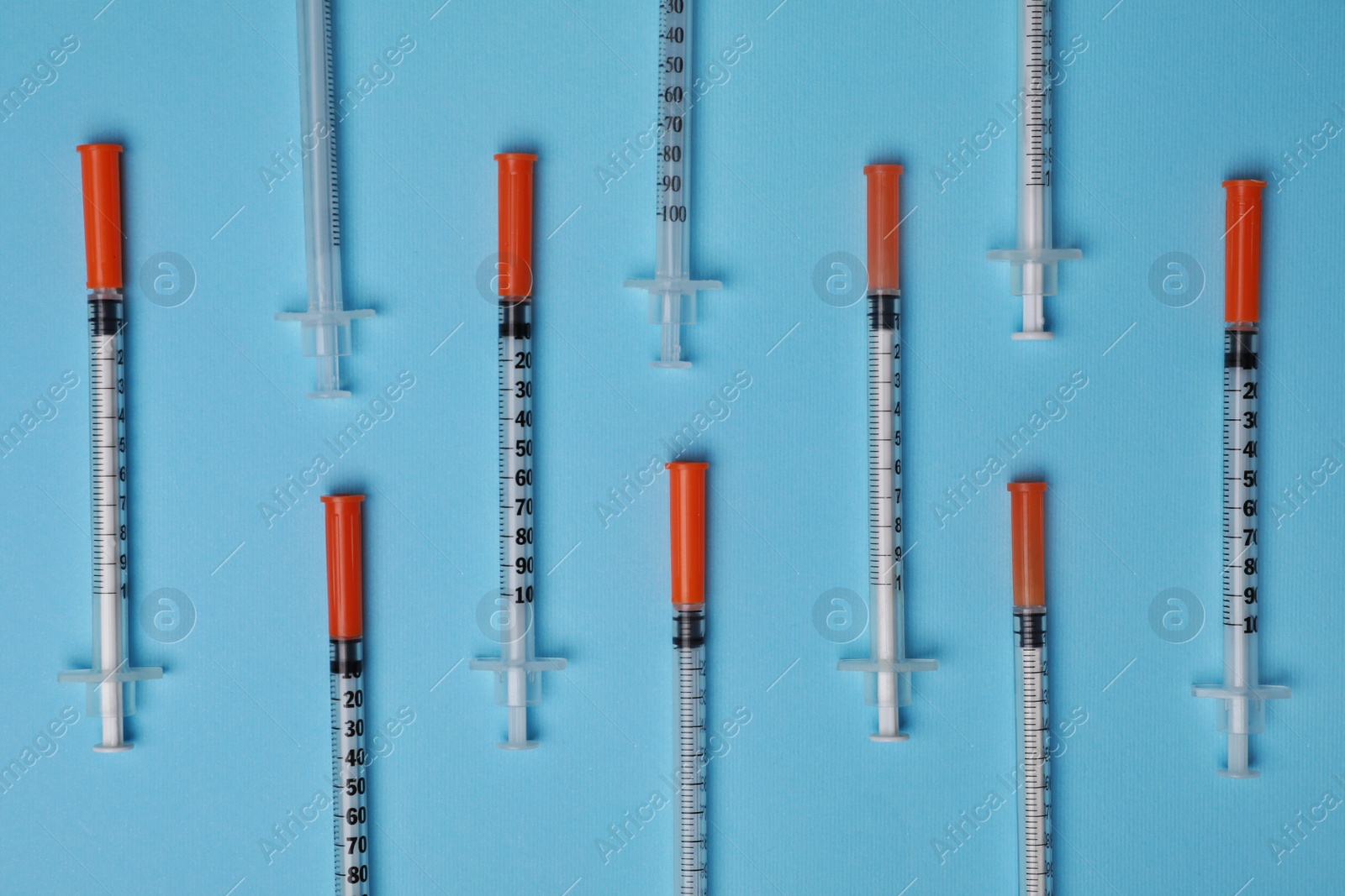 Photo of Disposable syringes on light blue background, flat lay