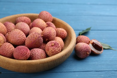 Photo of Fresh ripe lychee fruits on blue wooden table