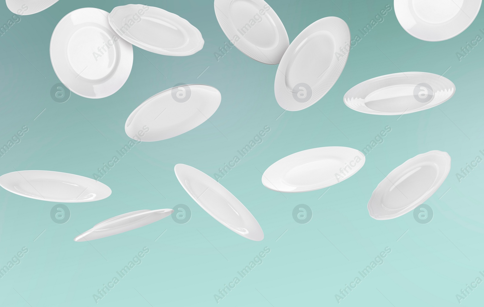 Image of Many white plates falling on pastel teal background