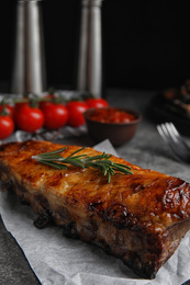 Tasty grilled ribs with rosemary on grey table