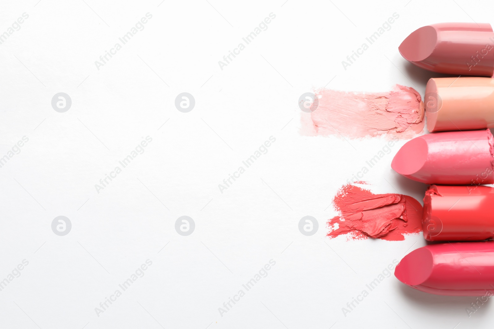 Photo of Different lipstick swatches on white background, top view