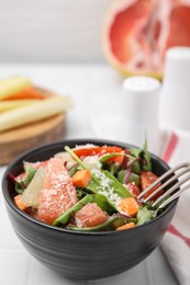 Delicious salad with pomelo, tomatoes and cheese on white tiled table, space for text