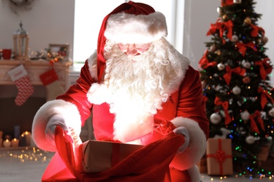 Photo of Authentic Santa Claus with bag of gifts indoors