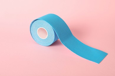 Photo of Bright kinesio tape in roll on pink background