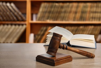 Image of Law. Judge's gavel and open book on wooden table indoors, space for text