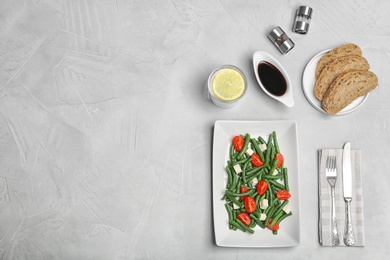 Tasty green beans with cheese and tomatoes served for dinner on table, top view