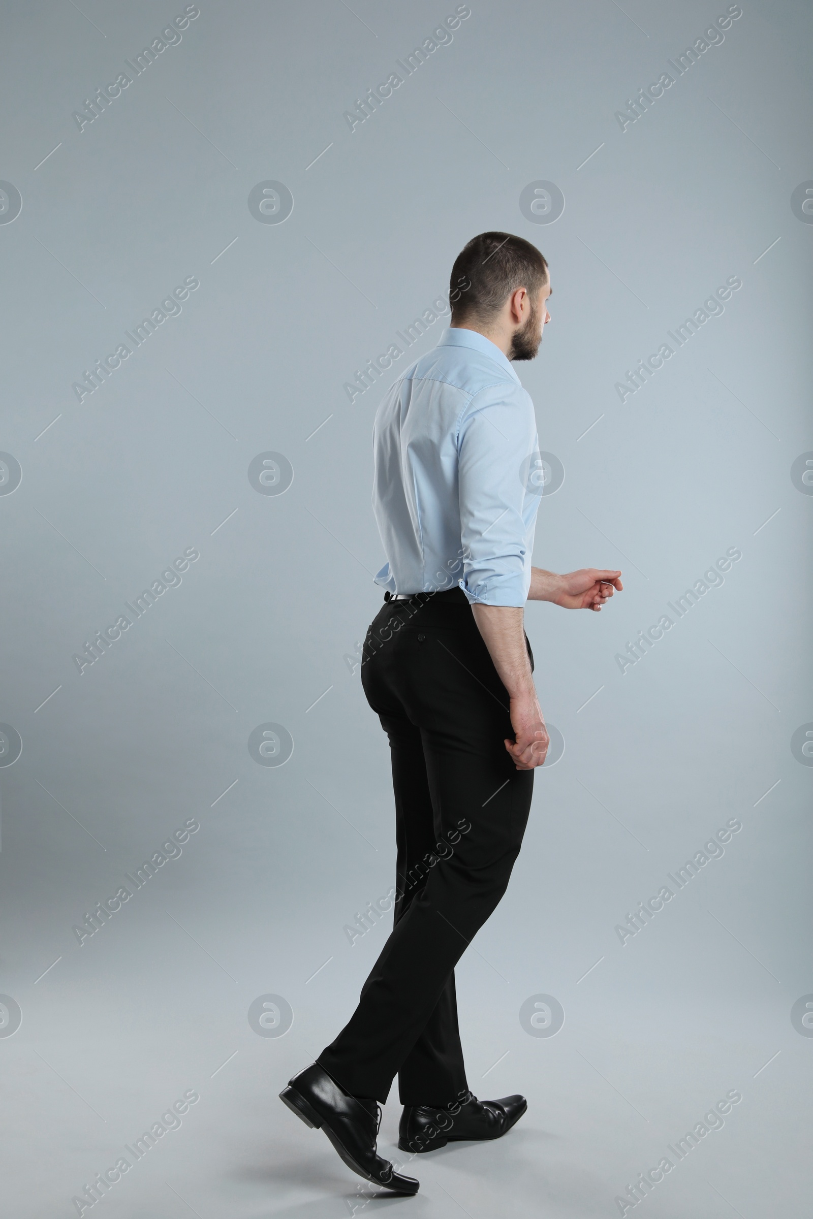 Photo of Professional businessman on grey background, back view