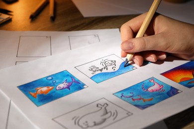 Photo of Woman drawing cartoon sketch in storyboard at workplace, closeup. Pre-production process