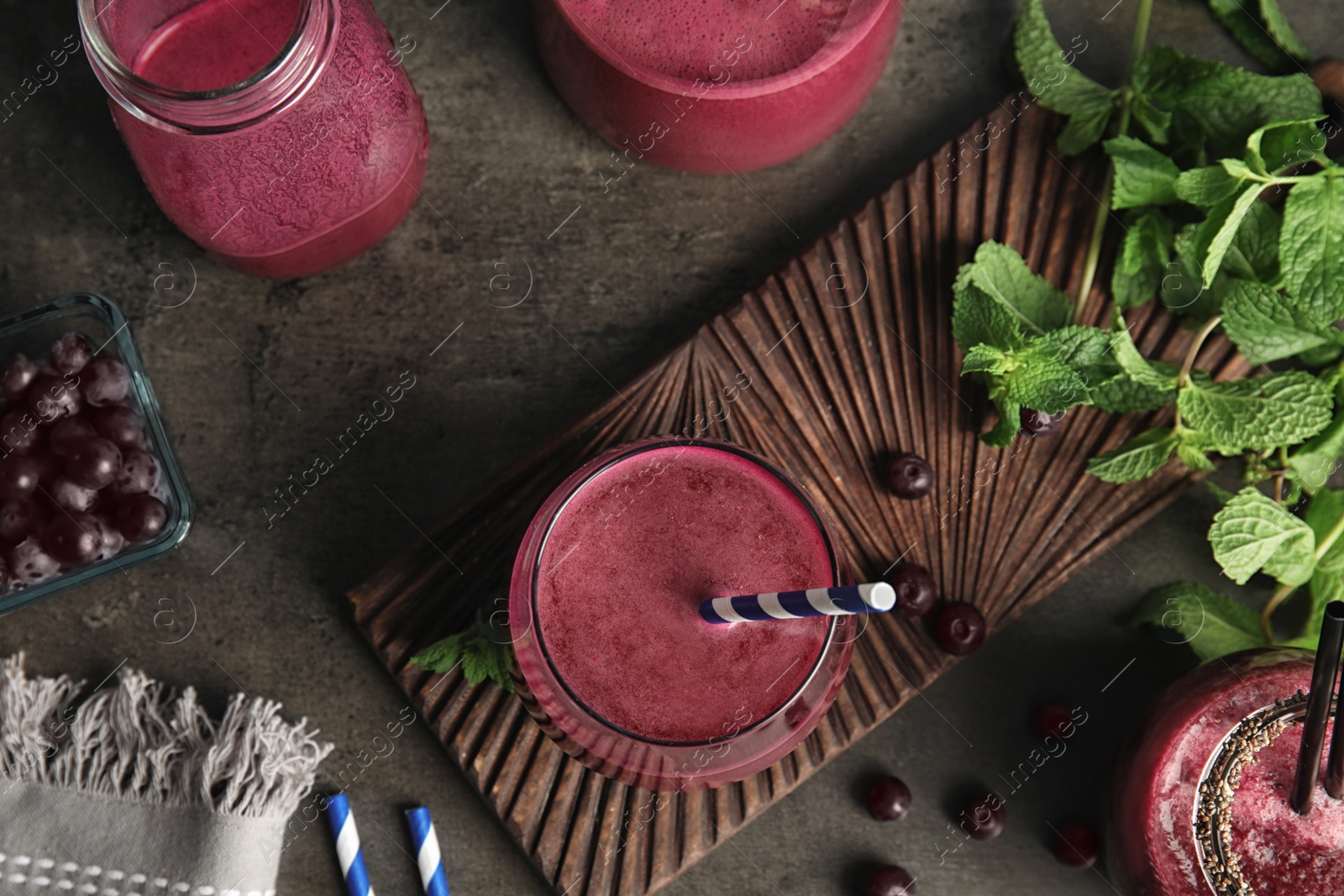 Photo of Flat lay composition with delicious acai juice on dark table