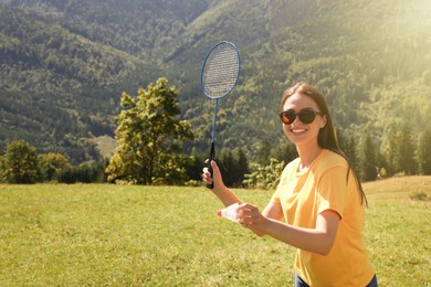 Woman playing badminton in mountains on sunny day. Space for text