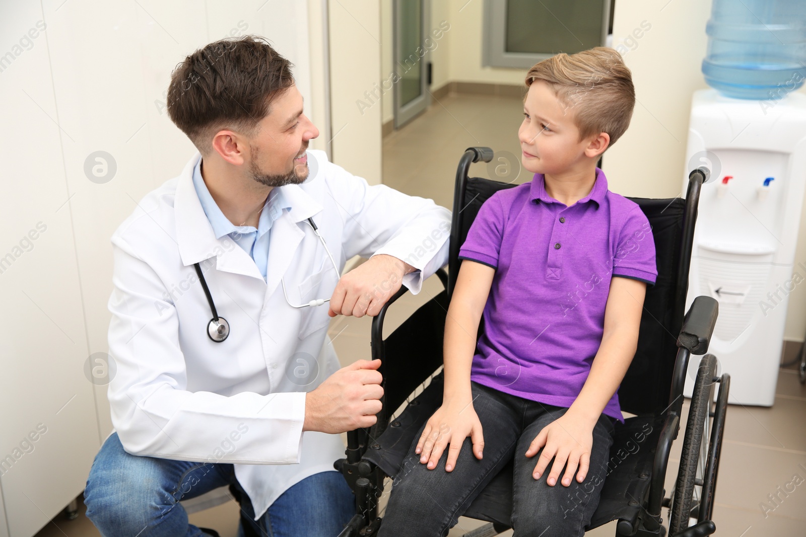 Photo of Doctor and little child in wheelchair at hospital