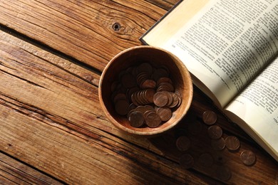 Photo of Donate and give concept. Bowl with coins and Bible on wooden table, flat lay. Space for text