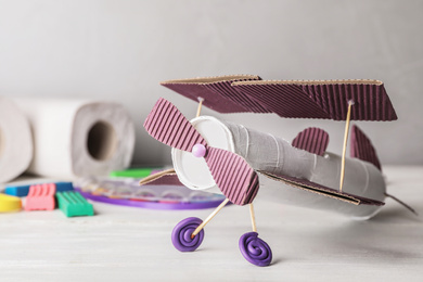 Toy plane made of toilet paper hub on white wooden table