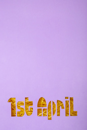 Photo of Phrase 1st APRIL cut out of lilac paper, top view with space for text. Fool's Day