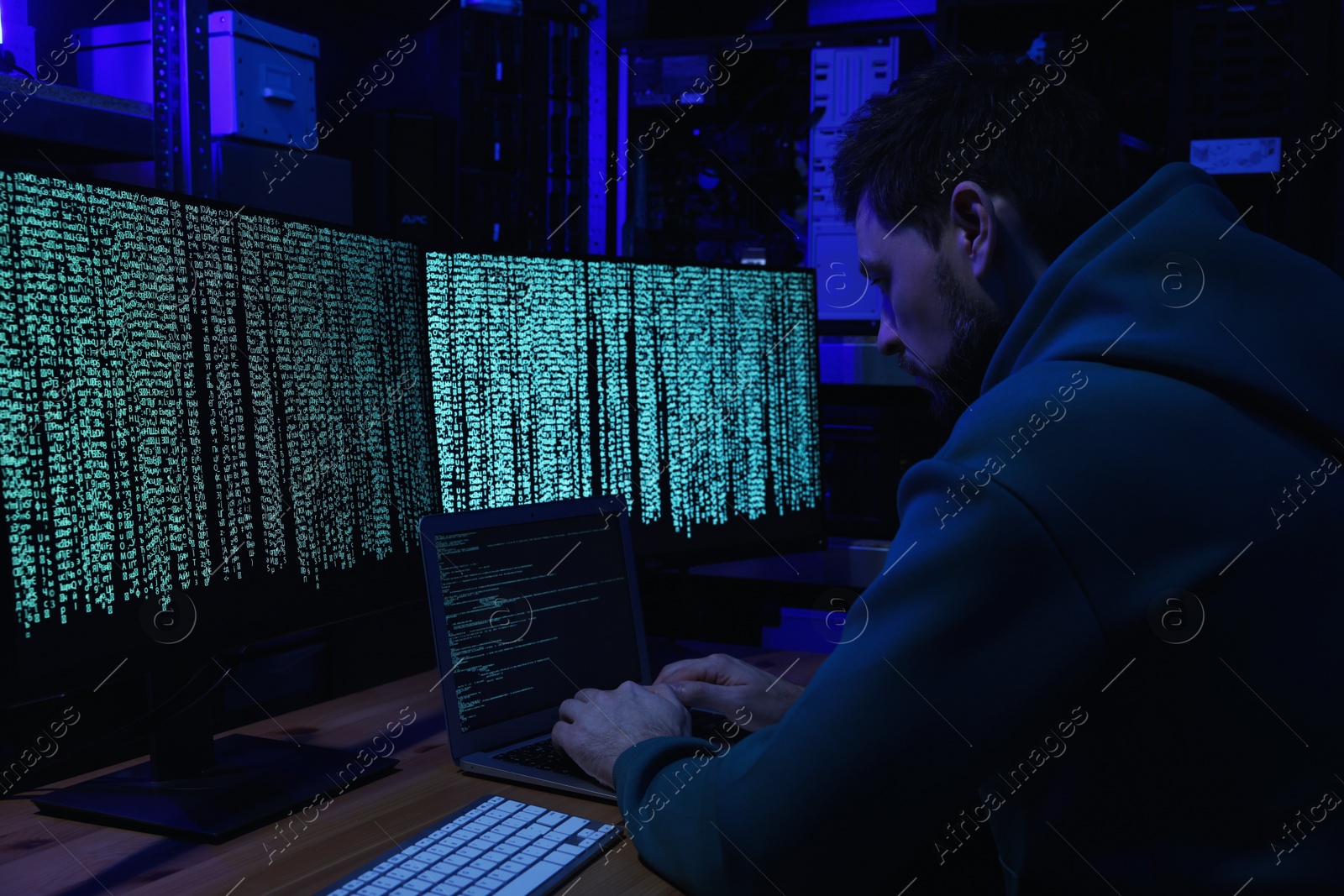 Photo of Hacker working with computers in dark room. Cyber attack