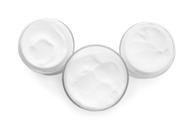 Jars of face cream isolated on white, top view