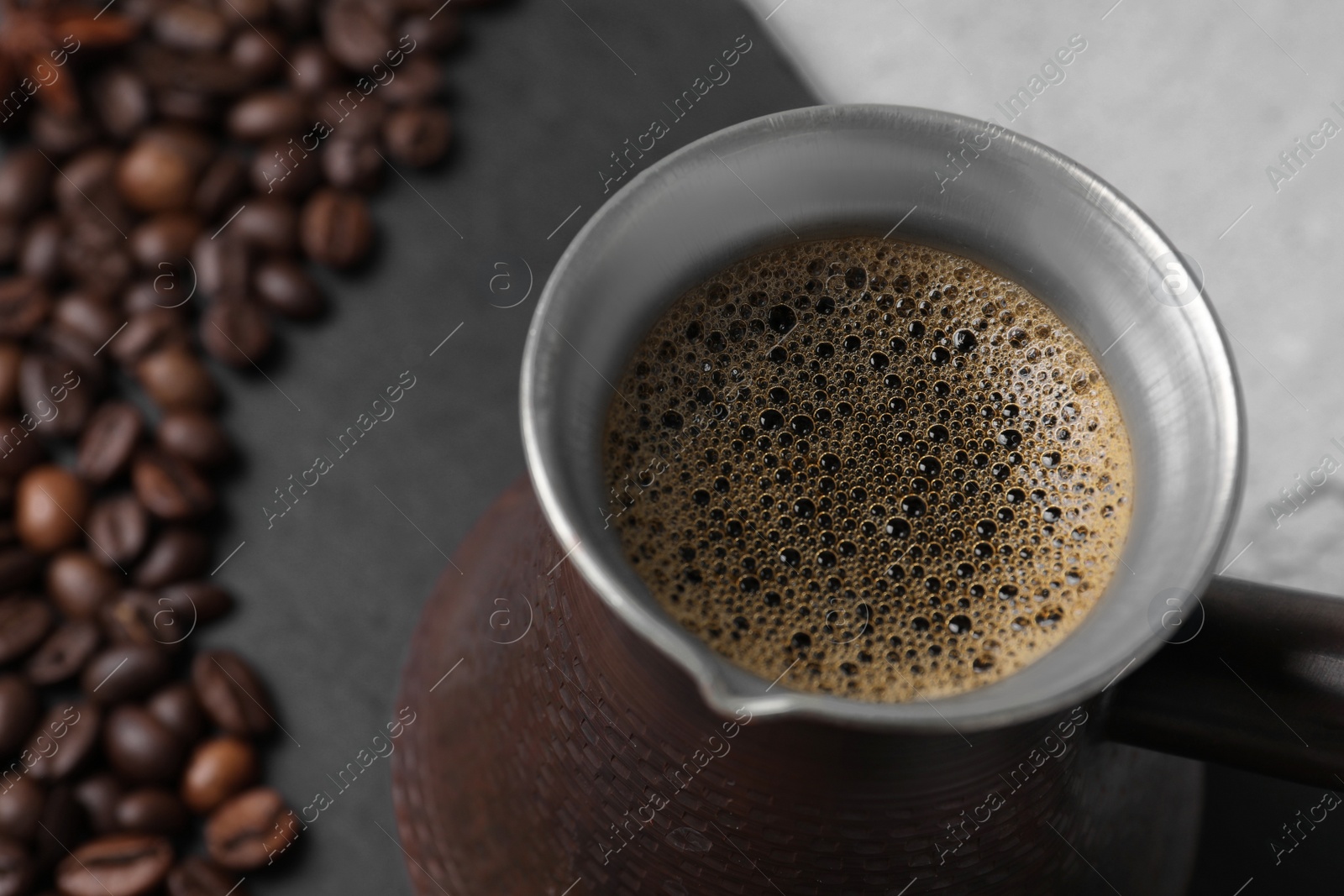 Photo of Turkish coffee in cezve on table, closeup