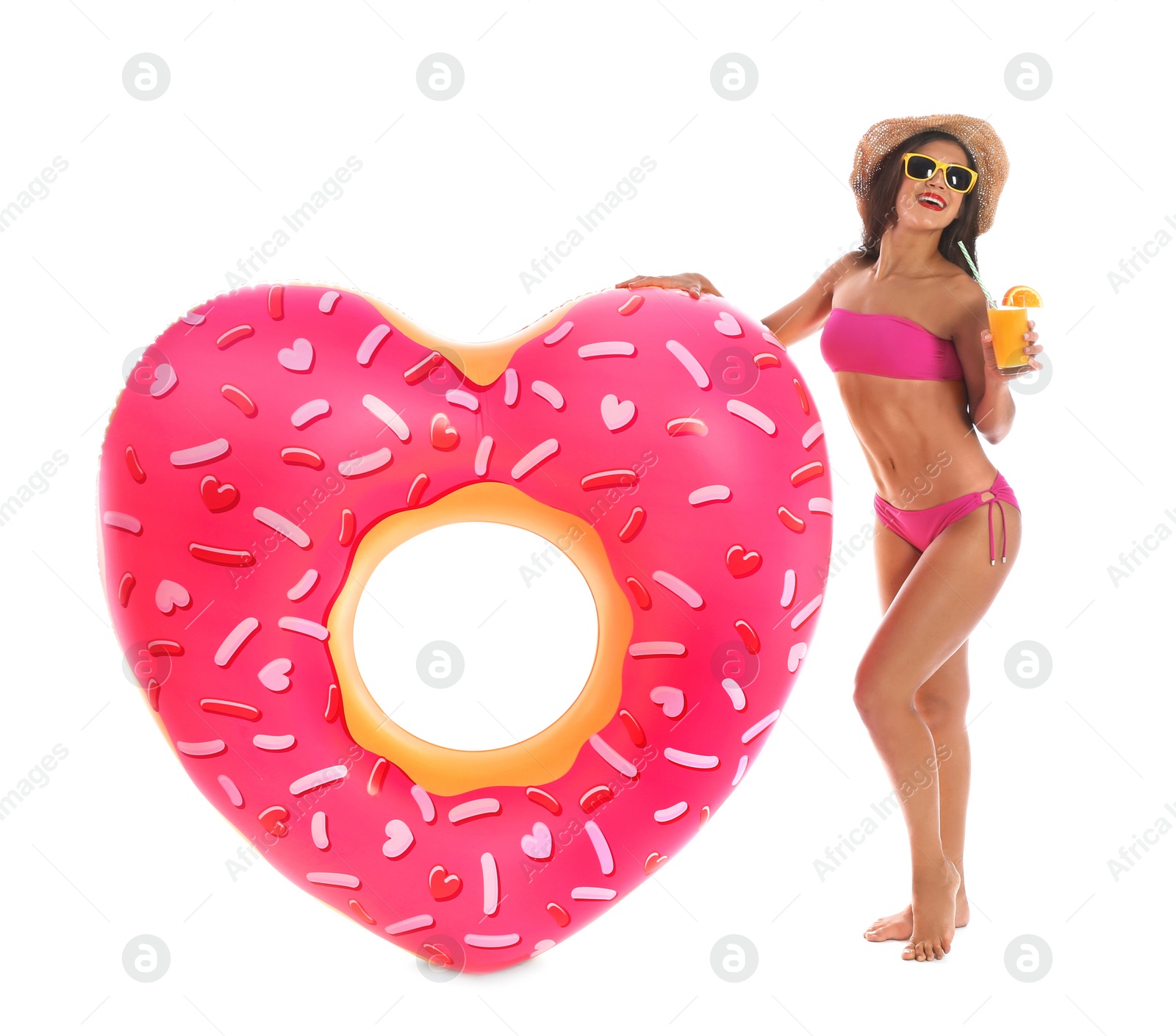 Photo of Beautiful young woman with inflatable heart and glass of cocktail on white background