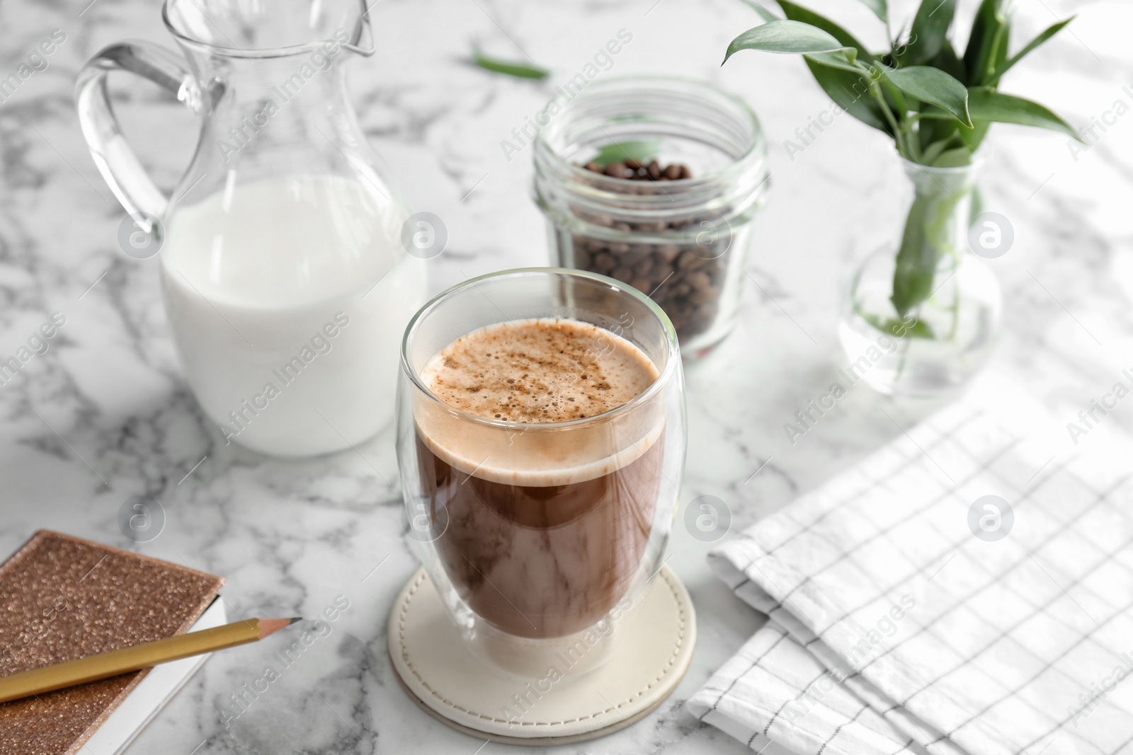 Photo of Glass of aromatic hot coffee on marble table