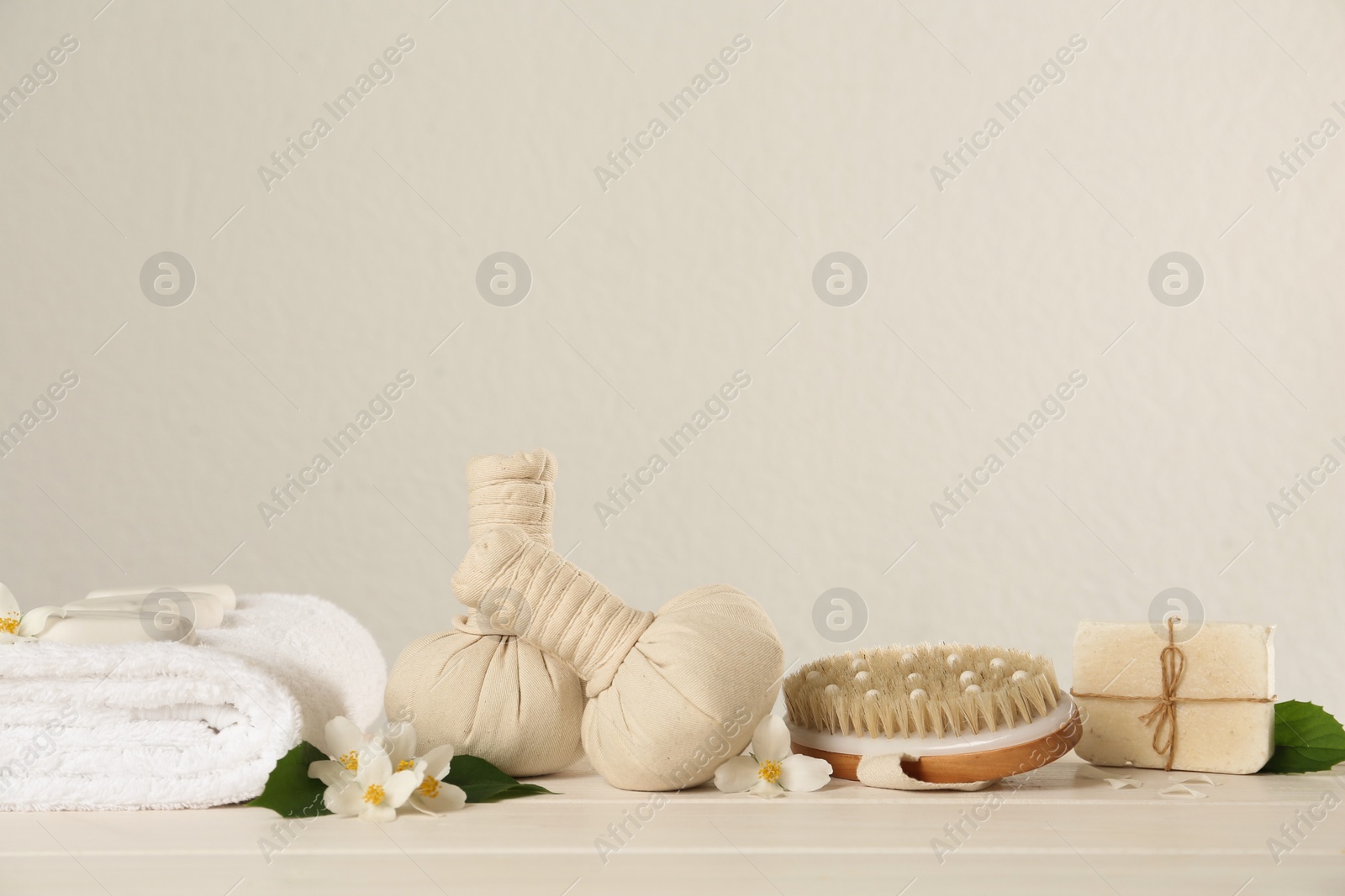 Photo of Composition with beautiful jasmine flowers and herbal bags on white wooden table, space for text