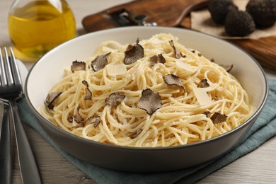 Photo of Tasty spaghetti with truffle on wooden table, closeup