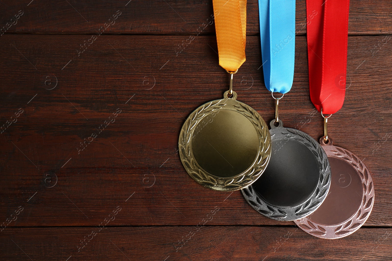 Photo of Gold, silver and bronze medals on wooden background, flat lay. Space for design