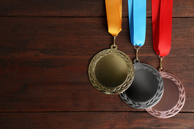 Photo of Gold, silver and bronze medals on wooden background, flat lay. Space for design