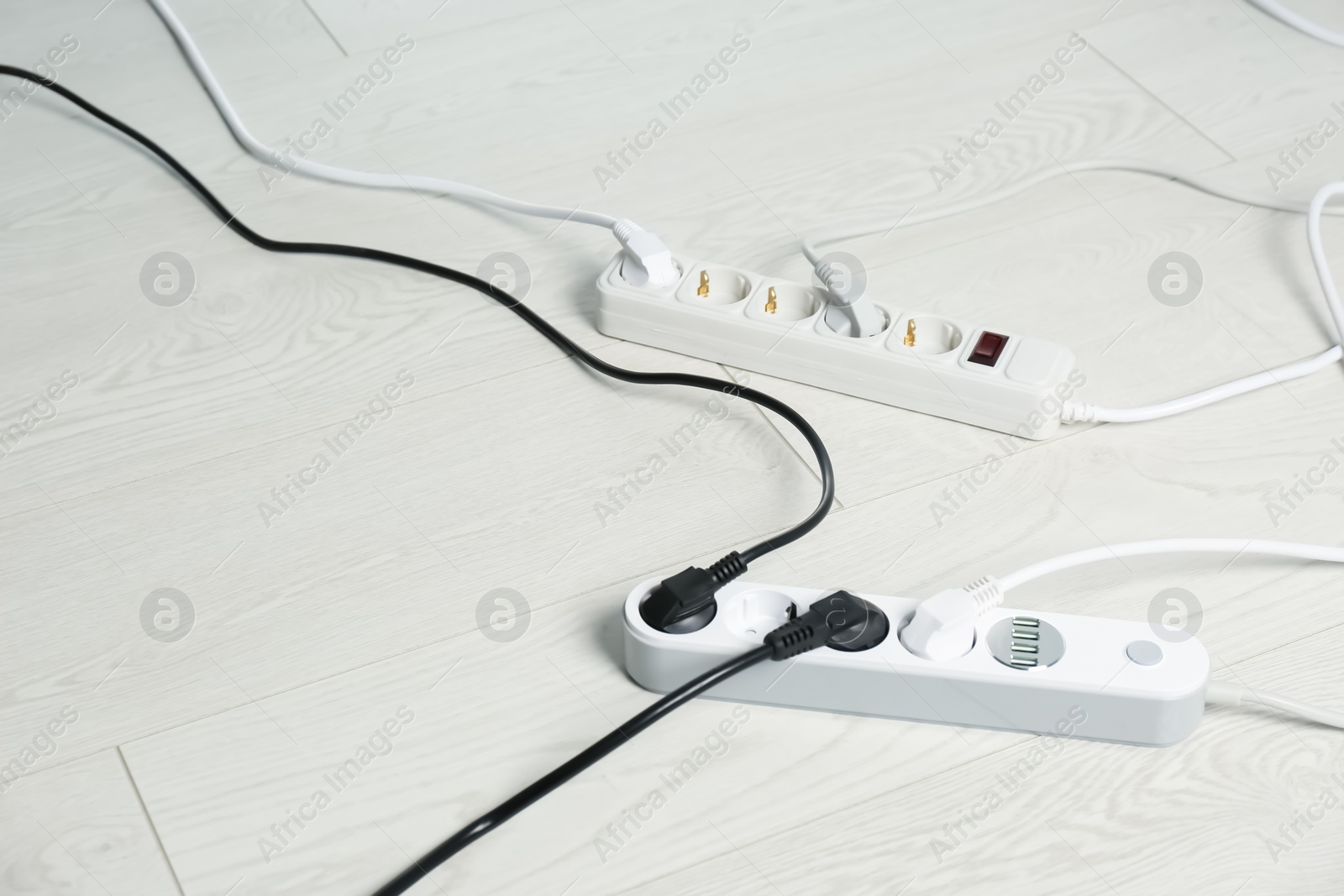 Photo of Extension cords on floor, space for text. Electrician's professional equipment