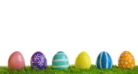 Photo of Painted Easter eggs on green grass against white background