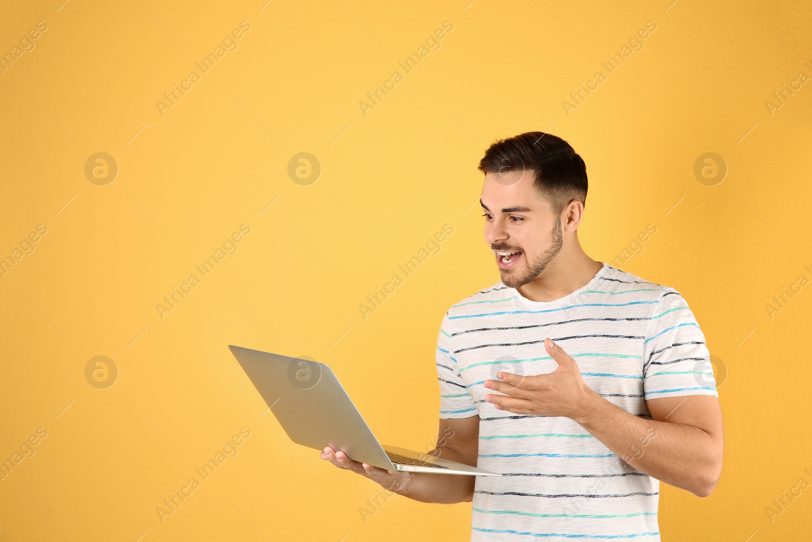 Photo of Man using laptop for video chat on color background. Space for text