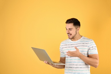 Man using laptop for video chat on color background. Space for text