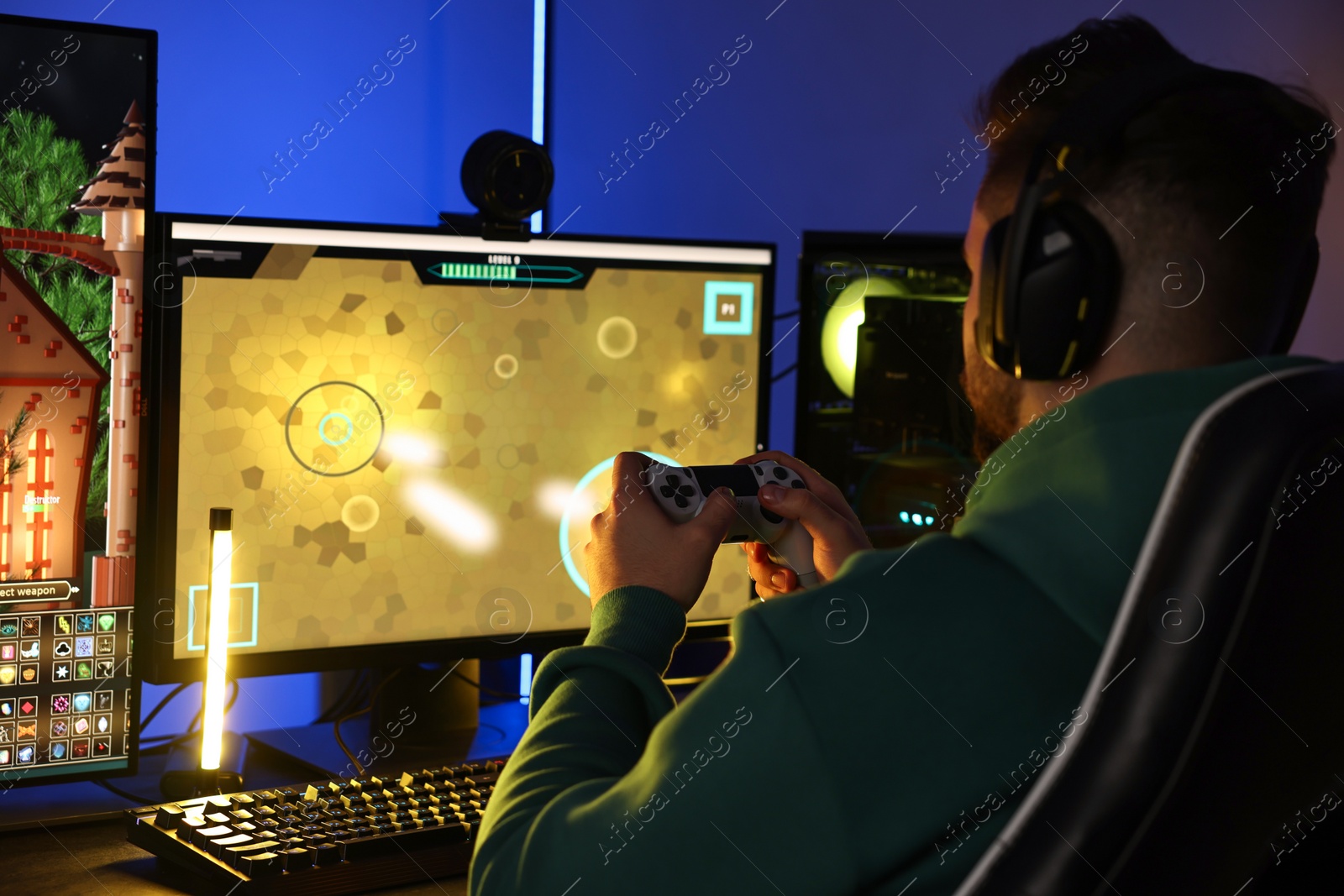 Photo of Man playing video games with controller at table indoors