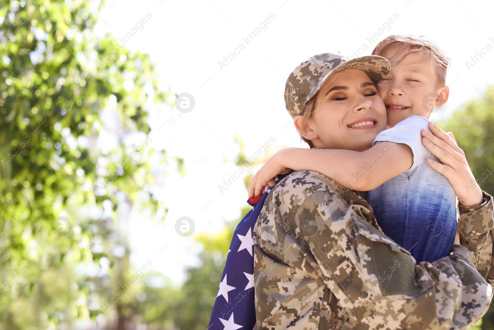Photo of American soldier with her son outdoors. Military service