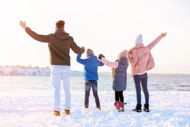 Photo of Happy family near river on winter day