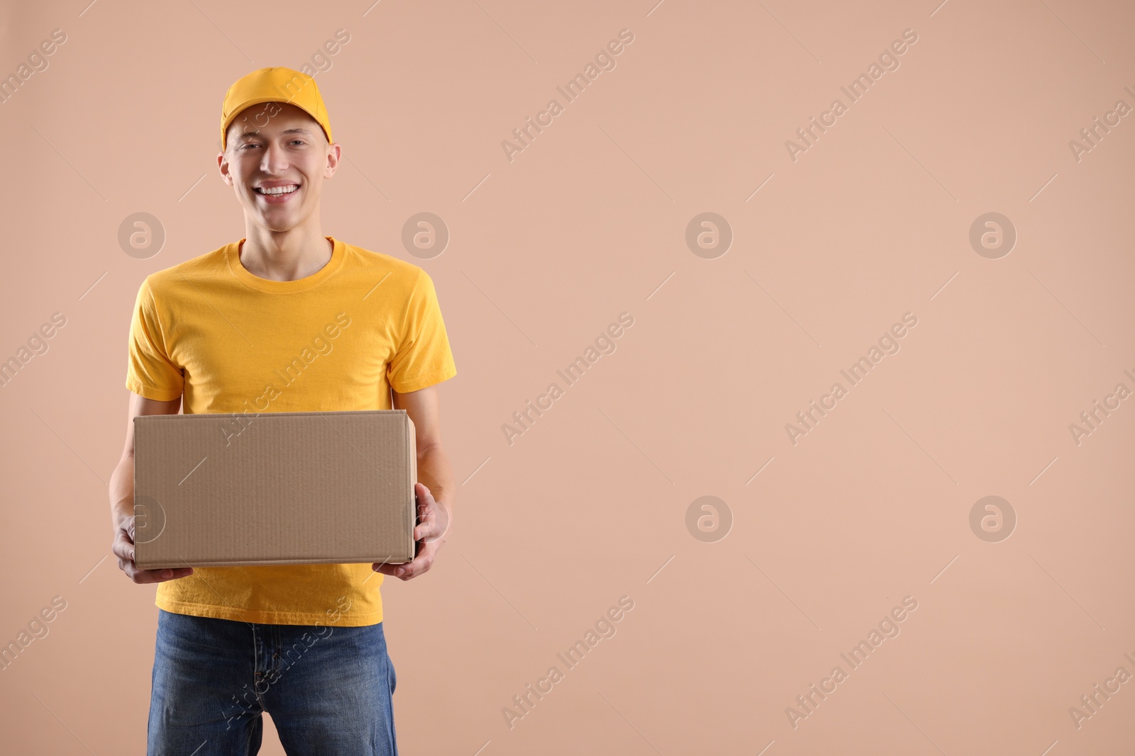 Photo of Happy courier with parcel on beige background. Space for text