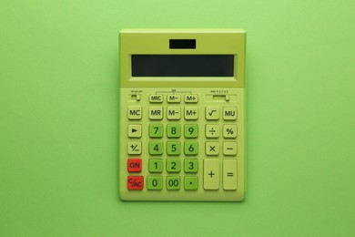 Modern calculator on green background, top view